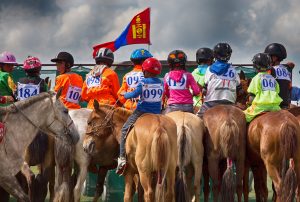 Mongolian children on their horses at the start line of a Naadam Festival horse race