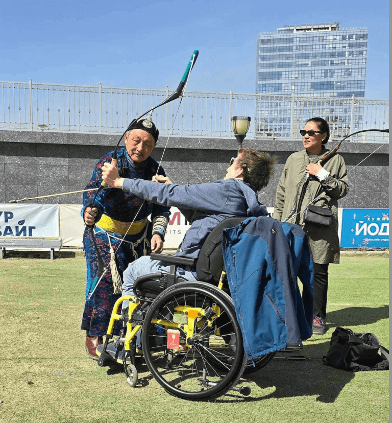 Wheelchair traveller in Mongolia practising archery