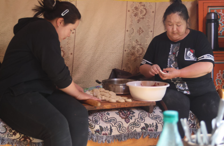 Two Mongolian women preparing dinner